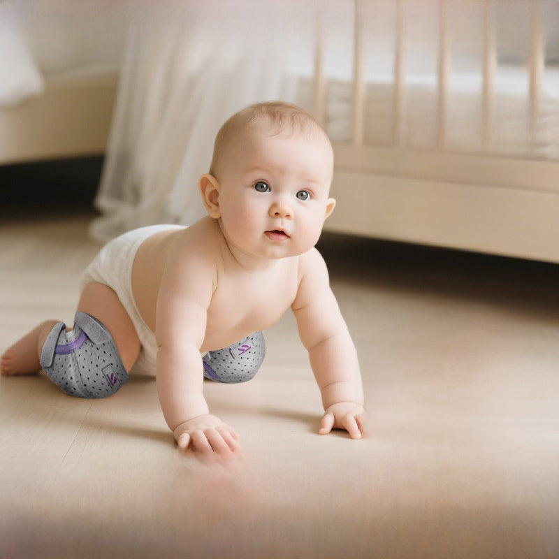 The baby is crawling with knee pads